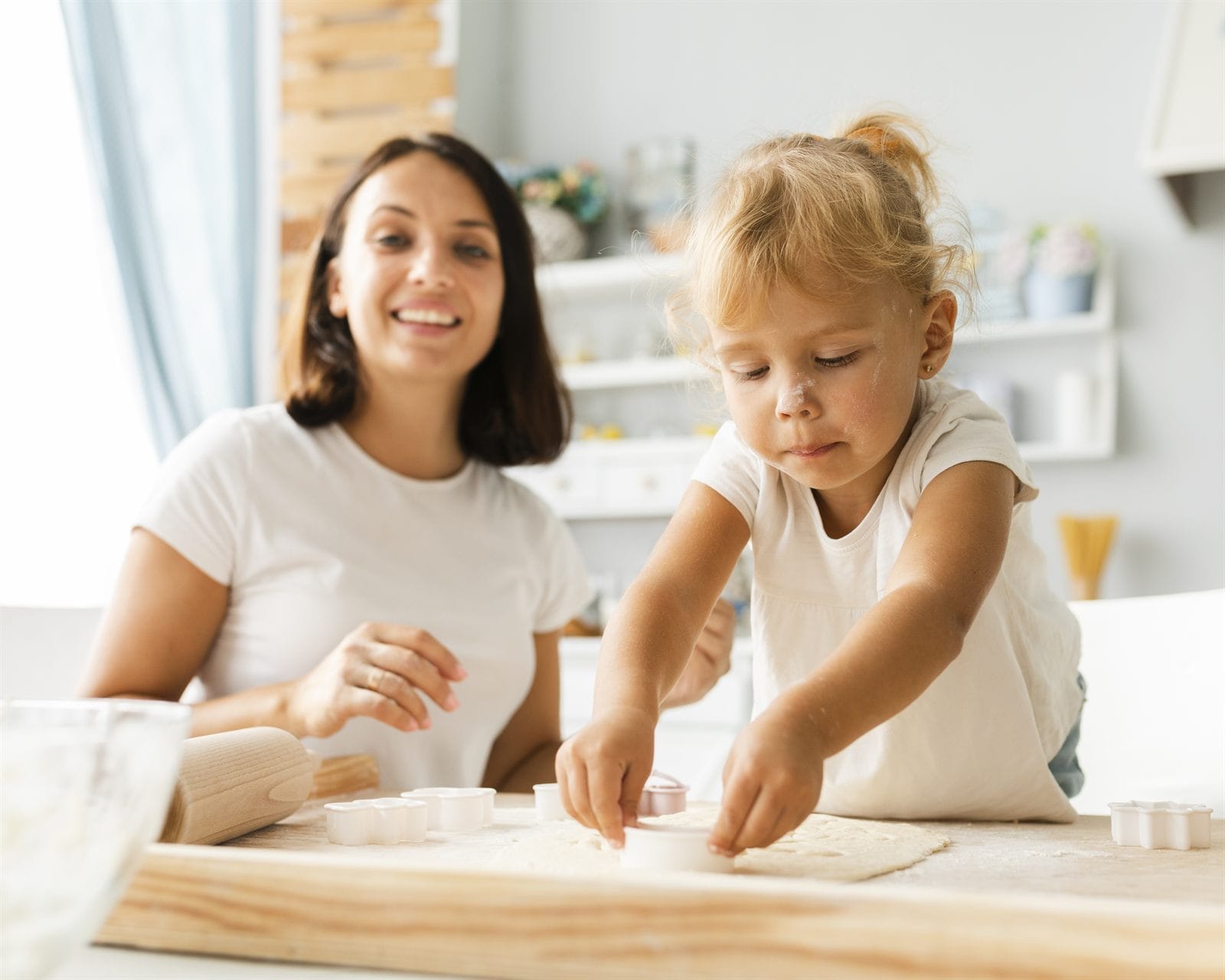A mother and daughter baking cookies together at home