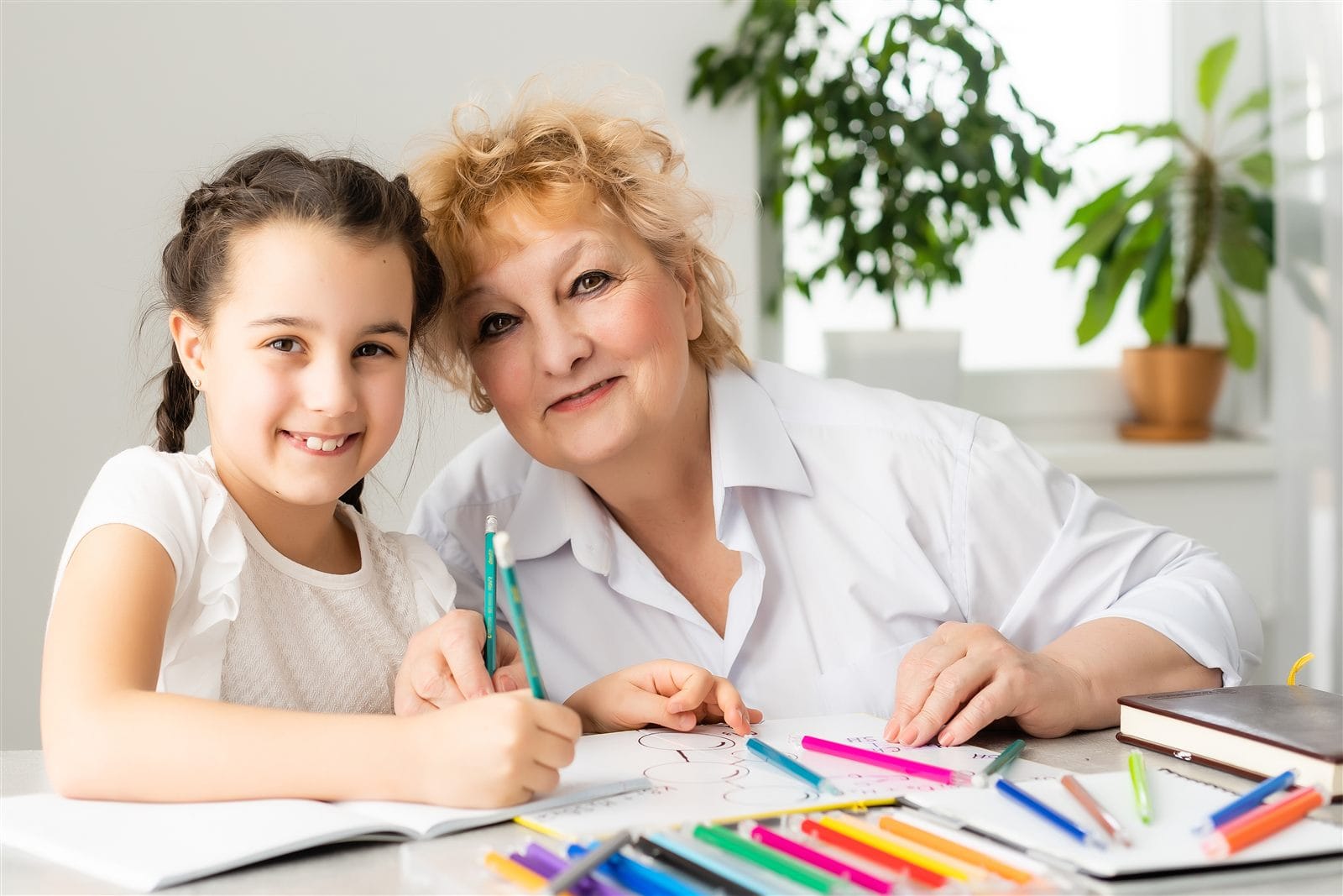 A grandmother and granddaughter doing homework together